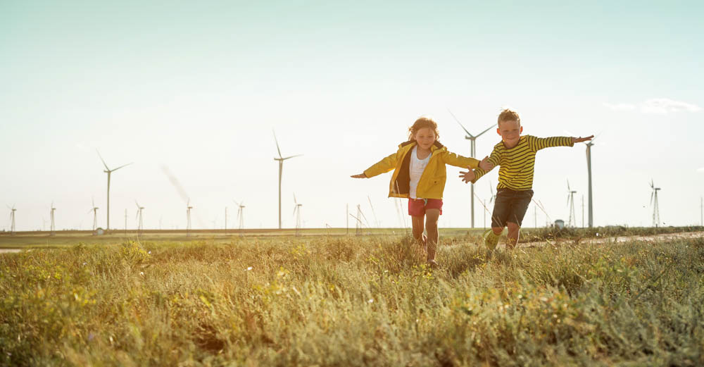 Regulatory and rate issues - Children running across a field of wind turbines